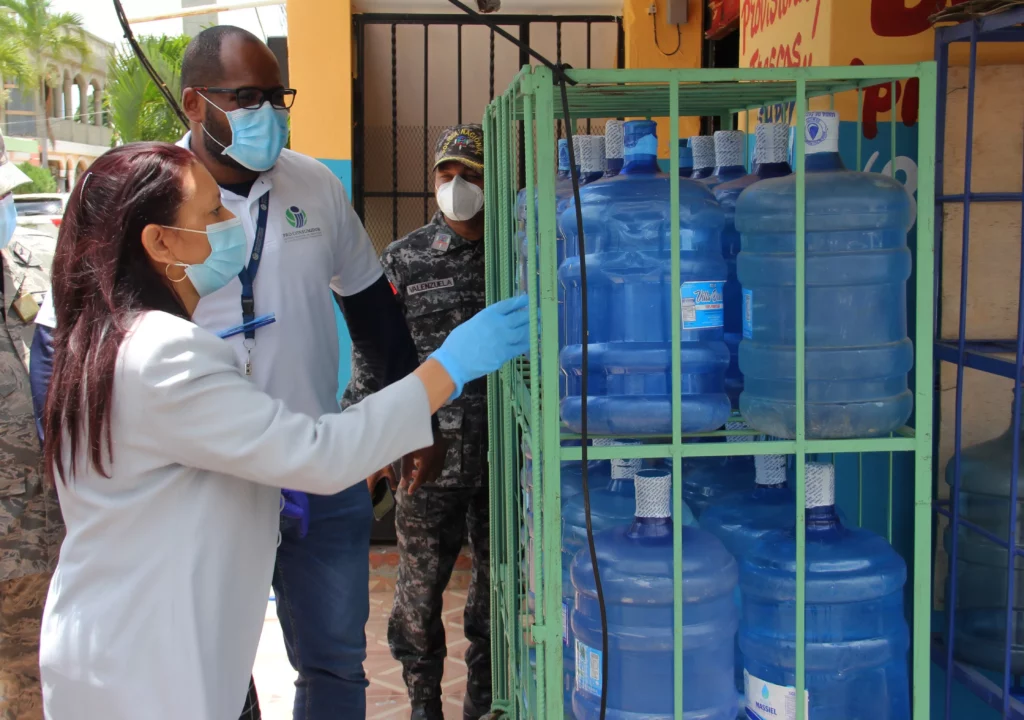 la subdirectora administrativa de pro consumidor maria teresa paulino supervisa botellones de agua plasticos en un establecimiento comercial