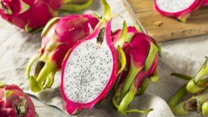 La fruta del dragón, también conocida como pitahaya, ofrece una serie de beneficios nutricionales y para la salud. Entre ellos, destaca su capacidad para fortalecer el sistema inmunológico gracias a su alto contenido de vitamina C, flavonoides, antioxidantes, y minerales como el calcio y el fósforo. Medicamentos GLP-1 en la mira: pérdida muscular y riesgo de rebote tras suspender el tratamiento Te puede interesar: Medicamentos GLP-1 en la mira: pérdida muscular y riesgo de rebote tras suspender el tratamiento Estos nutrientes, según los especialistas, contribuyen a la regeneración y al aumento de glóbulos blancos, esenciales para defender al cuerpo contra infecciones y daños celulares causados por radicales libres​. En cuanto a la salud cardiovascular, las semillas de pitahaya aportan ácidos grasos omega-3 y omega-9, los cuales ayudan a reducir el riesgo de enfermedades del corazón y a disminuir los niveles de colesterol LDL (el “malo”)​. Además, la pitahaya es rica en fibra, lo que favorece una digestión saludable, promoviendo el crecimiento de bacterias beneficiosas en el sistema digestivo, como las bifidobacterias y lactobacilos​. La realidad del autismo más allá del 2 de abril: retos y carencias en la sociedad, los sistemas de salud y educación Te puede interesar: La realidad del autismo más allá del 2 de abril: retos y carencias en la sociedad, los sistemas de salud y educación Semillas de pitahaya aportan omega-3 Semillas de pitahaya aportan omega-3 y omega-9, clave para la salud cardiovascular (Imagen ilustrativa Infobae) Por otro lado, la fibra contenida en la pitahaya también juega un papel importante en la regulación de los niveles de azúcar en sangre, especialmente en personas con diabetes tipo 2, ayudando a reducir el azúcar en sangre hasta en un 19%​. Además, estudios científicos mostraron que el licopeno, un antioxidante presente en la pitahaya, puede ayudar a reducir las células cancerosas, con investigaciones apuntando a su posible beneficio en la prevención y tratamiento del cáncer de mama​. Día Mundial de Concienciación sobre el Autismo: un llamado urgente hacia la inclusión social Te puede interesar: Día Mundial de Concienciación sobre el Autismo: un llamado urgente hacia la inclusión social La fruta también tiene propiedades antiinflamatorias que pueden aliviar el dolor y la hinchazón, ayudando con condiciones como la artritis reumatoide​. Por último, sus nutrientes como la vitamina C y antioxidantes contribuyen a una piel más saludable, ayudando a tratar el acné y a prevenir el envejecimiento prematuro​. Tipos de fruta del dragón La fibra de la pitahaya La fibra de la pitahaya ayuda a regular azúcar en sangre y mejora la digestión (Imagen Ilustrativa Infobae) Según las documentaciones, existen diversas especies de pitahaya que se cultivan comercialmente, aunque la clasificación de estas puede generar controversia debido a la hibridación de especies. Las tres principales especies son: Hylocereus undatus: esta variedad tiene una piel de color rosa brillante y una pulpa blanca, siendo la más común en los mercados. Hylocereus sp.: caracterizada por una piel de color rosa brillante y pulpa rosada o con tonalidades variadas. Selenicereus megalanthus: con piel amarilla y pulpa blanca, esta especie también se cultiva para la producción comercial​. Sabor y textura de la fruta del dragón El sabor y la textura de la pitahaya varían según la especie aunque, en general, se caracteriza por un sabor ligeramente dulce que recuerda a una combinación entre kiwi, pera y un toque de sandía madura. Algunas variedades pueden tener un sabor ligeramente ácido​. En cuanto a la textura, es similar a la de una pera o un kiwi maduros, siendo algo granulada y crujiente, con un toque acuoso. La pulpa de la pitahaya, ya sea roja, rosada o blanca, contiene diminutas semillas negras comestibles, similares a las del kiwi​. El licopeno en la fruta El licopeno en la fruta del dragón podría reducir células cancerígenas, según estudios (Imagen Ilustrativa Infobae) El sabor también puede depender del color de la pulpa: la pitahaya blanca suele tener un sabor más suave, mientras que las variedades de pulpa roja y oscura tienden a ser más jugosas y dulces. La pitahaya verde, por otro lado, puede carecer de sabor​. Desglose nutricional de la fruta del dragón La pitahaya es una fruta baja en calorías y abundante en nutrientes esenciales. Una porción de 100 gramos de esta fruta contiene: Calorías: 60 Proteínas: 1,18 g Grasas: 0 g Carbohidratos: 12,9 g Fibra: 2,9 g Azúcares: 7,65 g Calcio: 18 mg Hierro: 0,74 mg Magnesio: 40 mg Sodio: 0 mg Vitamina C: 2,5 mg Tiamina (B1): 0 mg​. Cómo comer y almacenar la fruta del dragón La pitahaya se puede consumir cruda de diversas maneras. Una de las formas más comunes es cortar la fruta por la mitad y comer la pulpa directamente con la cuchara o cortarla en rodajas. La piel de la fruta no es comestible, pero la pulpa jugosa se disfruta fácilmente. También se puede incorporar a ensaladas de frutas, licuados, y otros productos como helados o mermeladas​. Diferentes especies de pitahaya ofrecen Diferentes especies de pitahaya ofrecen variedad de colores, sabores y texturas (Imagen Ilustrativa Infobae) Para conservar la pitahaya, recomiendan refrigerarla, ya que no madura después de ser recolectada. A temperatura ambiente, puede mantenerse fresca durante cuatro a cinco días, mientras que en refrigeración puede durar hasta cuatro semanas​. Dónde encontrar la fruta del dragón Según el Centro de Recursos de Marketing Agrícola Ag MRC, de Estados Unidos, la pitahaya es originaria de México y se cultiva en toda América Central y Sudamérica, con países como Nicaragua y Ecuador destacándose como grandes productores. También se cultiva en diversas regiones de Asia, especialmente en Vietnam, que es el principal productor de la región. Otros países asiáticos, como Malasia, Filipinas y Tailandia, también producen esta fruta​. En Estados Unidos, la pitahaya se cultiva principalmente en California, Florida y Hawái, aunque la mayor parte se importa desde el sudeste asiático​.